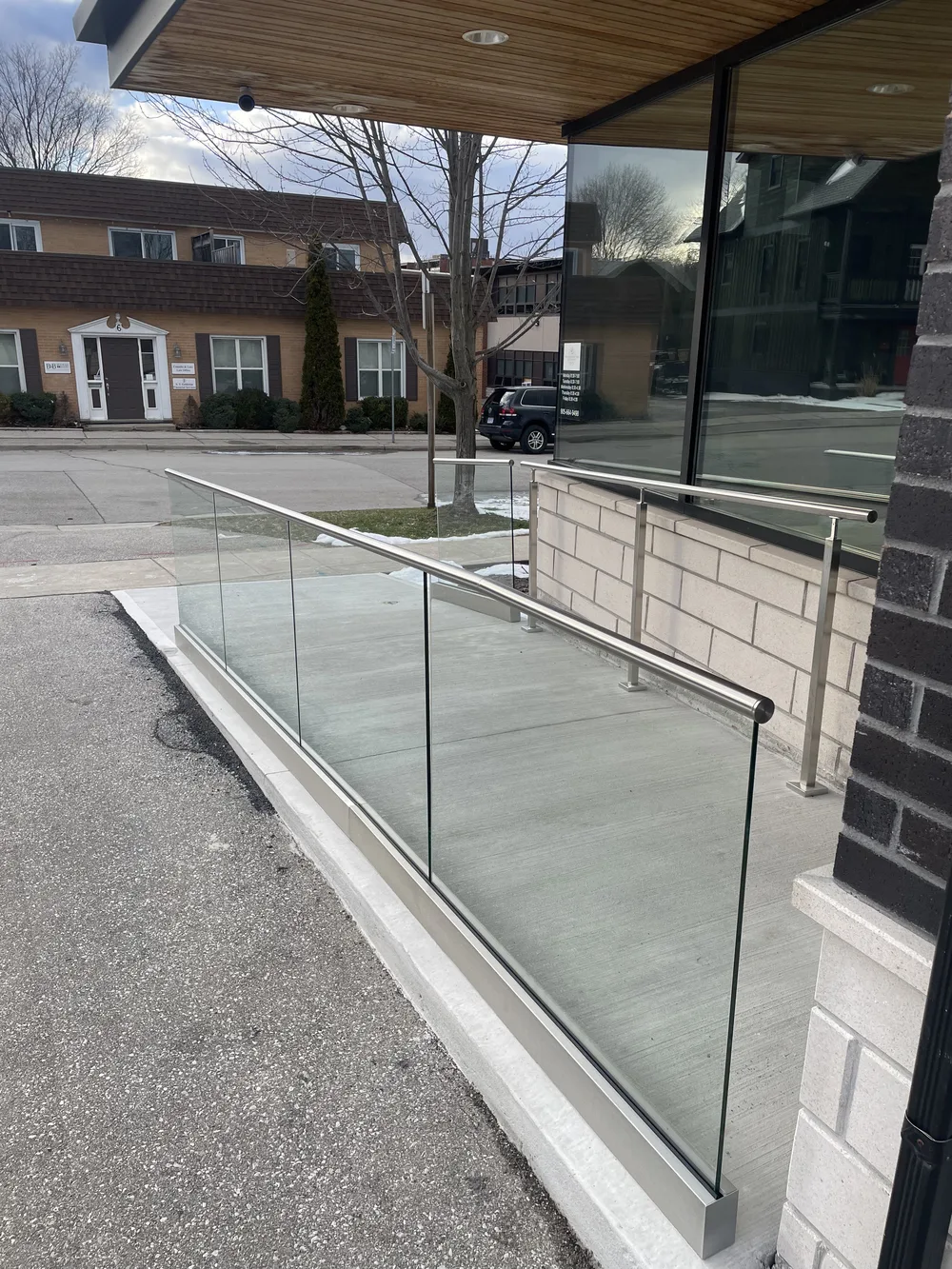 Sleek modern glass railings installed on a commercial access ramp