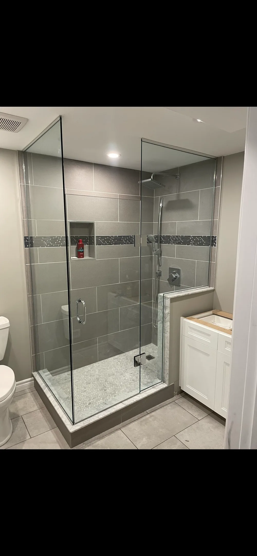 Corner glass shower enclosure on half-wall