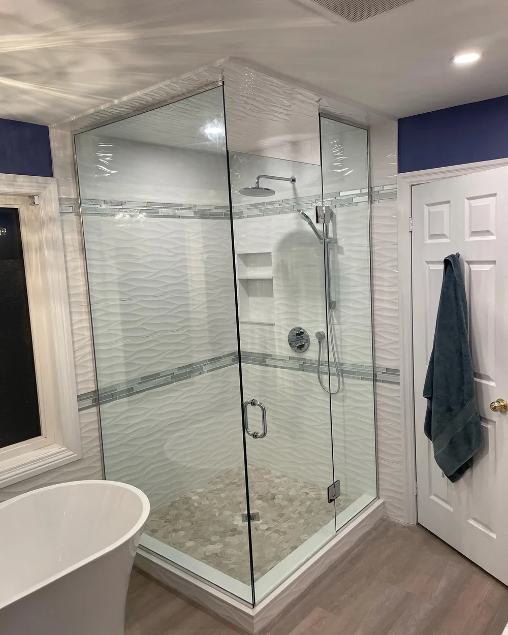 Glass shower with wave-patterned tiles