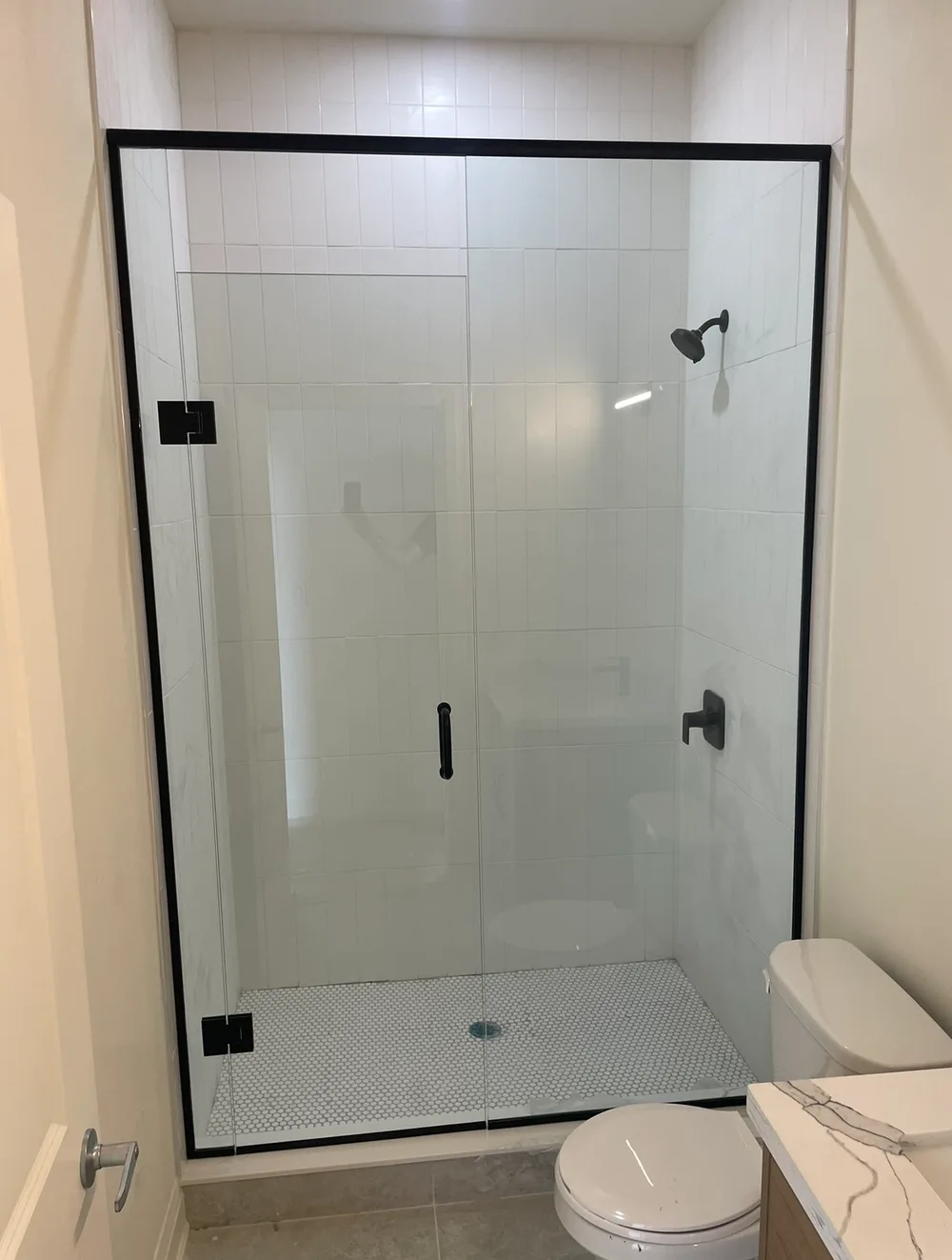 Luxury custom glass shower enclosure installation with premium hardware